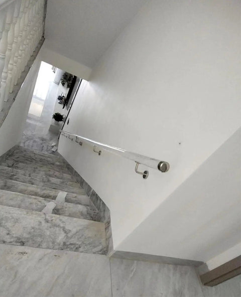 Crystal Clear Acrylic Stair Handrail With Rock Solid Silver Wall Mount Brackets Custom Length Non Slip Transparent Safety Railing For Buttery Smooth Daily Walks on stairway with marble steps.