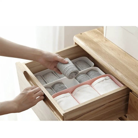 Slick Four Compartment Plastic Underwear Storage Box For Closet Dresser Drawers, organizing socks and leggings in a wooden drawer.