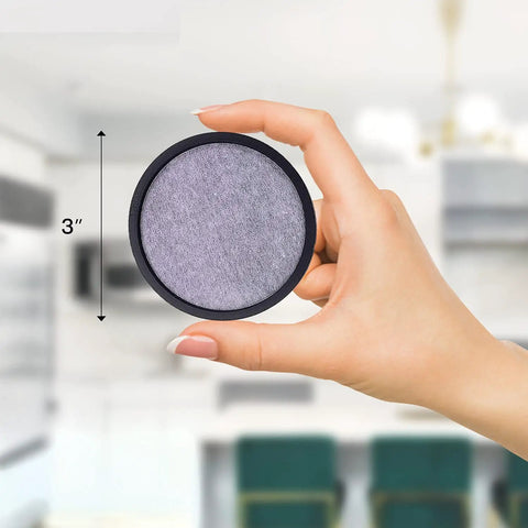 Hand holding a 3-inch disc from 24 Pack Replacement Charcoal Water Filter Discs For Coffee Makers And Brewers in kitchen.