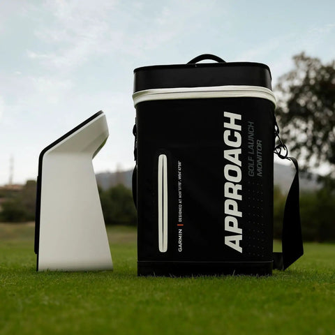 Approach R50 Golf Launch Monitor And Simulator Bundle featuring display case on grass with trees in background