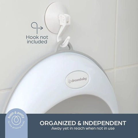 Toddler Non Slip Potty Training Seat hanging on a wall, featuring a grey soft cover and convenient storage for travel.