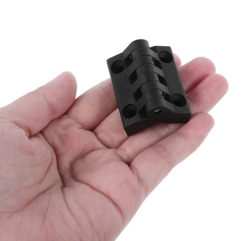 Black Plastic Cabinet Door Hinges 1.57 Inch Screw Mount Lift Off Enclosure Hinges in hand, showing compact design