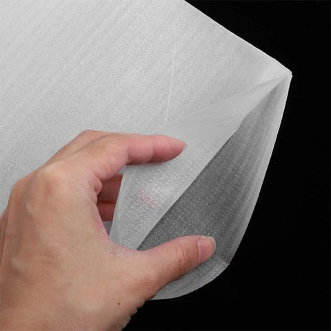 Close-up of a hand holding Epe Foam Pouches 200 Pack For Moving And Shipping Cushioned Protection, showcasing the white foam material.