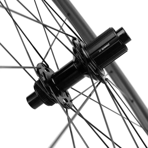 Close-up of the hub of a Carbon Disc Wheelset 50C-25 Clincher Road Wheels UD Matte Finish Six Bolt showcasing spoke alignment.