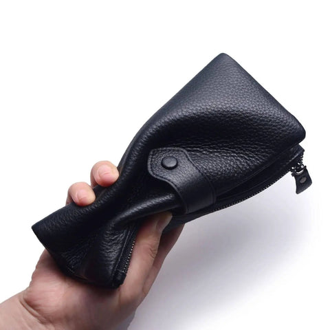 Hand holding a compressed Women's Soft Leather RFID Blocking Bifold Slim Wallet With Double Zipper Pockets 17 Card Slots And ID Window For Everyday Carry Secure Stylish Card Holder Black