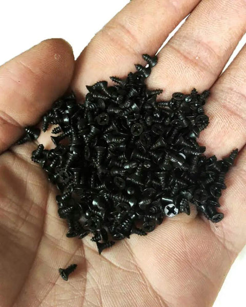 Sweet Little Flathead Phillips Wood Screws With Antiqued Black Finish For No Sweat Assembly On Lumber Garden Gear And Diy Crafts Comes Ready With One Hundred Pieces, held in a hand.