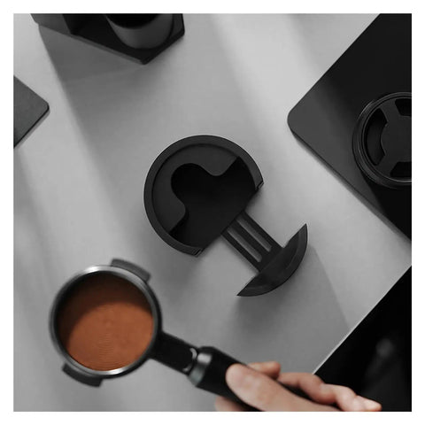 Heavy Duty Adjustable 51 53 58 Millimeter Portafilter Holder Tamping Platform Crafted From Tough Aluminum on a workspace with portafilter.