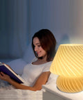 Woman reading by Swirl Mushroom Lamp With Vintage Striped Murano Glass on bedside, emitting warm white light, 9.9 inch tall