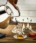 Pouring hot water from Specialty Stainless Steel Tea Kettle, 2 Quart, Induction Ready Pot with Visible Fill Line and Whistle into a cup