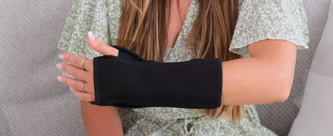 Woman wearing Carpal Tunnel Wrist Brace Night Support With Splint Stabilizer And Palm Cushion, adjustable, black material