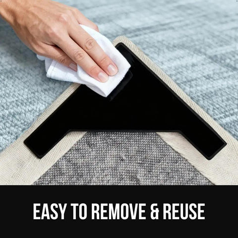 Hand removing Extra Wide Dual Sided Rug Gripper Pads for Hardwood Floors and Tile from corner of area rug.