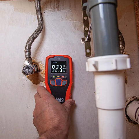 Person using moisture meter from Home Inspector Tool Kit With Digital Moisture Meter, Non Contact Voltage Tester, And GFCI Outlet Tester.