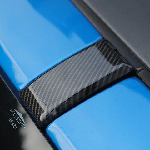Close-up of Premium Carbon Fiber Windshield Screw Covers For Ford Bronco 2021 To 2023 left bezel on blue surface.