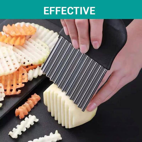 Side view of large stainless steel crinkle cutter with black handle slicing potatoes into crinkle-cut fries.