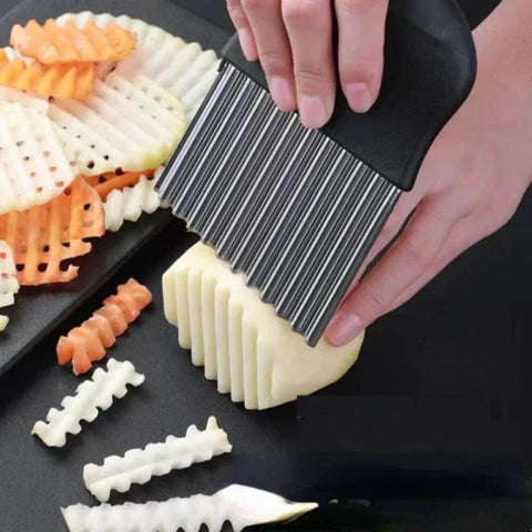 Crinkle cutter knife, stainless steel, used to slice potatoes into crinkle-cut fries (close-up).