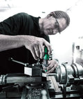 Person using Micro ESD Adjustable Torque Screwdriver 2.0 To 6.0 Ncm With Quick Release Chuck on machinery in a workshop.