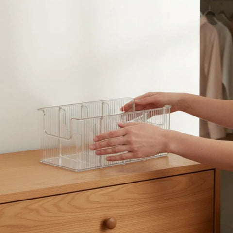 Person arranging Top Shelf Crystal Clear Acrylic Belt Organizer With Removable Dividers Stackable Storage Bin for ties and watches.