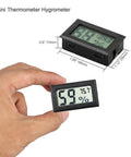 Hand holding Four Pack Mini Digital Temp And Humidity Meters With Probes, A 2 In 1 Thermometer Hygrometer With LCD Display
