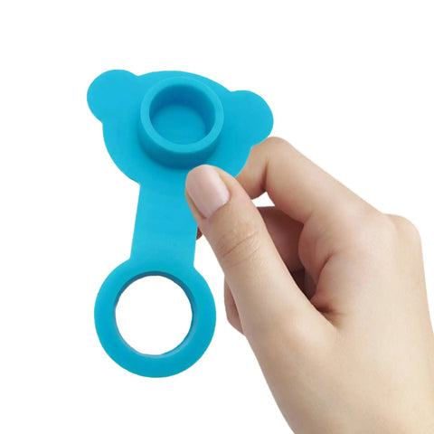 Hand holding a blue silicone bathtub drain plug stopper for easy removal, featuring a round grip and soft material.