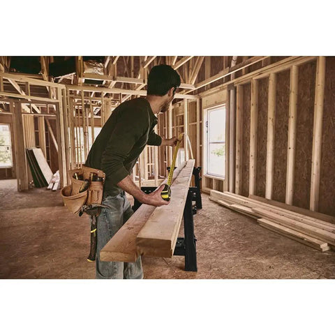 Man using FatMax Auto Lock Tape Measure 25 Ft With 1-1/4 Inch Wide Blade Detachable End Hook Quick Lock in construction site