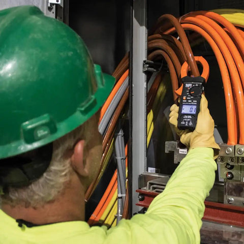 Electrician using Digital Clamp Meter With Auto Range TRMS For AC DC Voltage And Current Up To 2000A in industrial setting