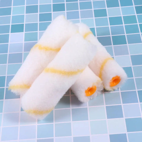 Thirty Mini Paint Roller Sleeves High Density Cotton Refills For Tight Corners Baseboard Trim with orange ends on a tiled background.