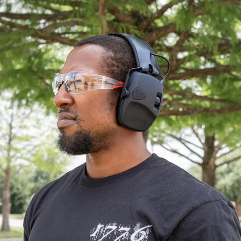 Man wearing Electronic Hearing Protection Earmuffs NRR 22 DB Rating with clear safety glasses outdoors.