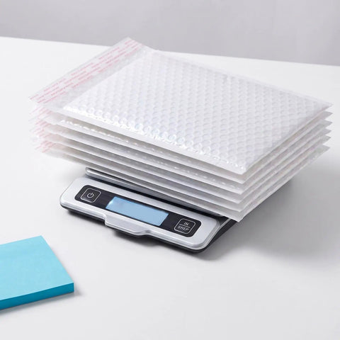 Stack of 30 Pack 6 By 8 Inch Bubble Mailers Self Seal Envelopes Waterproof Protective Mailing Bags on digital scale