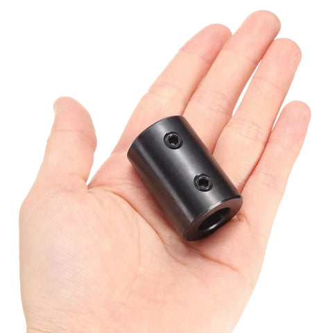 Person holding Beefy Rigid Shaft Coupling With Set Screws Five Eighths Inch Bore One And One Quarter Inch OD Two Inch Long Black Oxide Steel