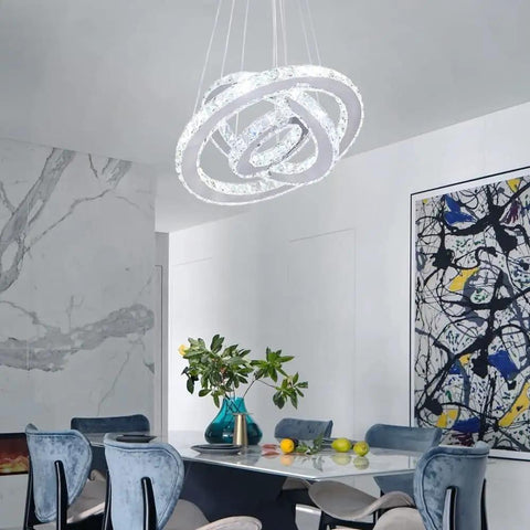 Modern LED Crystal Chandelier With 3 Ring Pendant Lights Adjustable Stainless Steel Ceiling Fixture for a dining room.