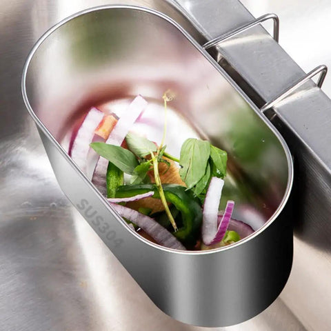 Super Solid Stainless Steel Hanging Sink Strainer Basket that Makes Catching Food Scraps Absolute No Sweat for Kitchen Drains Filters Gunk And Washes Produce Dead Simple Silver Finish with vegetable scraps inside.