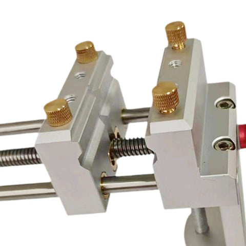 Close-up of the metal jaws of a Small Bench Vise For Home Workshop And Jewelry Making, 360 Degree Rotating Table Vice with gold knobs.