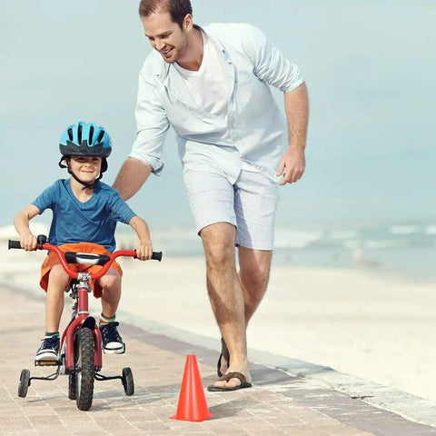 Father guides child cycling by a 12 inch traffic training sports cone, 10 pack or 24 pack orange safety markers for outdoor practice.