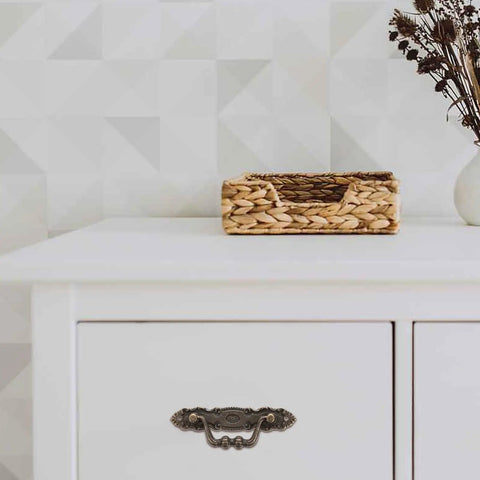 Antique Zinc Alloy Cabinet Handles Set For Wardrobe And Furniture on white dresser with decorative basket nearby.