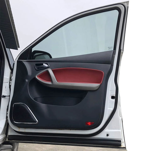 Open driver-side car door interior panel of a white vehicle, black and red trim.