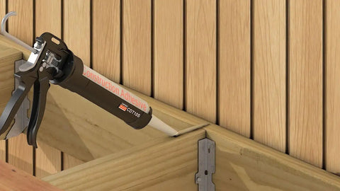 Applying adhesive to wood joist in deck construction with EB-TY Premium Hidden Deck Fastening System With Two And One Quarter Inch Type 305 Stainless Screws