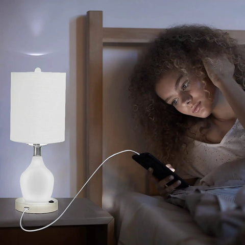 Emergency Battery Back Up Table Lamp With USB Charging And Color Changing Base next to woman in bedroom at night