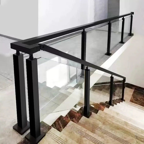 Modern glass railing with black metal supports along a staircase, combining safety and style in an indoor setting.