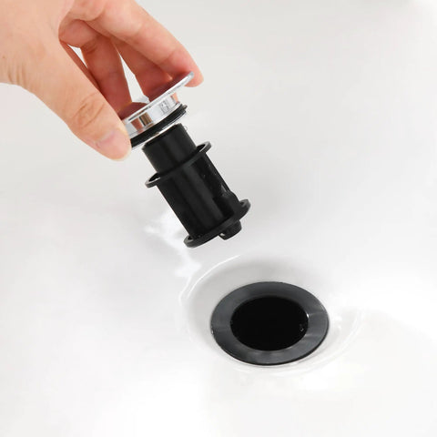 Heavy Duty Chrome Pop Up Bathroom Sink Drain With Overflow Stopper held above sink, showcasing smooth glide design and installation.