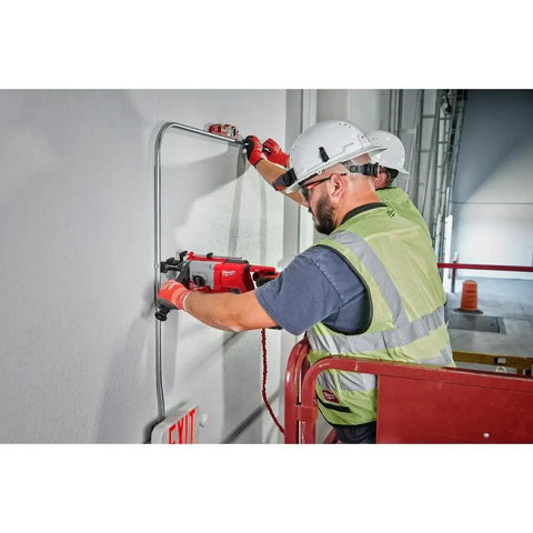 Top Shelf Brushless M18 Rotary Hammer With D Handle And Sds Plus Chuck drilling into concrete on a job site.