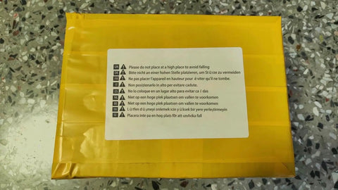 Close-up of a yellow package with warning labels about placement instructions for safety.