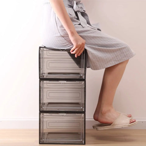 Person sitting on stacked Six Pack Clear Purse And Handbag Display Boxes with Acrylic Magnetic Doors, medium size organizer.