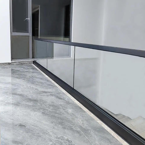 Heavy Duty Glass Railing System For Deck And Balcony Featuring Rock Solid Spigot Clamps with matte black aluminum posts on a modern floor.
