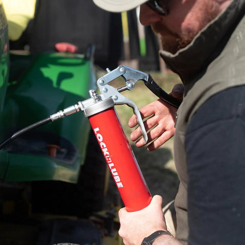 LockNLube heavy-duty pistol-grip grease gun, red body with metal trigger and hose.