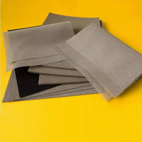 Stack of lab-grade conductive foam EMI shielding sheets on a yellow background, ideal for experimental setups and electronics manufacturing.