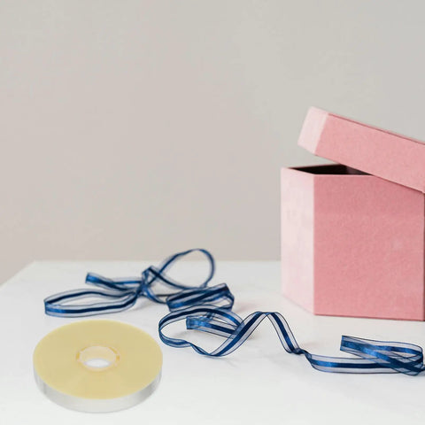 Heavy Duty Strapping Tie For Machines And Box Packaging Pro Grade Fast Easy Packing Tape For Shipping next to pink box