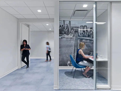 Modern office space with glass wall and city mural, featuring White Vinyl Wall Base 4 Inch By 40 Feet Self Stick Trim.
