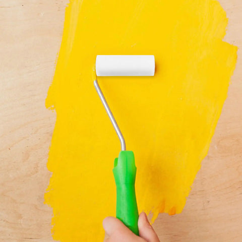 Pro Level Sponge Paint Rollers For Wall Texturing And Drywall Finishing Deliver Seamless Even Coverage Quick Swap Haul With Comfortable Grip Handles, using a green handle roller on a yellow wall.