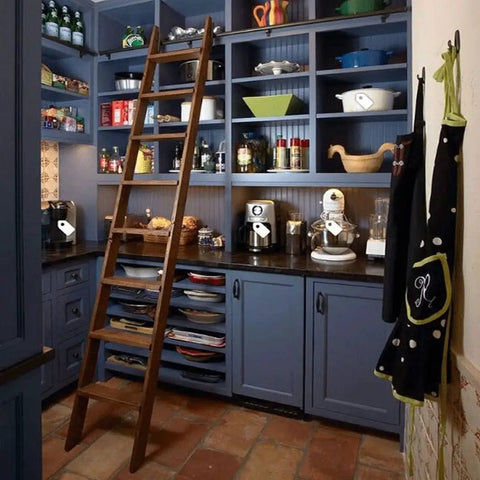 Wooden ladder in a kitchen pantry with blue cabinets and various kitchenware, showcasing the potential space for Rolling Library Ladder Rail Kit Sliding Hardware For Round Tube Track System No Ladder Included For Garage And Closet Mounts Carbon Steel Black Finish 13ft 400cm Length installation.