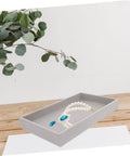 Three Piece Multi Grid Jewelry Organizer Trays Featuring Earring Stands Necklace Display Plates And Soft Velvet Ring Inserts To Make Sorting Your Bling A Breeze For Home Or Showroom Use, showing a grey tray with pearls and blue gem.